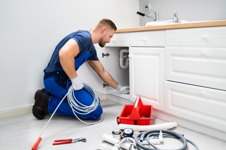 Male,Plumber,Cleaning,Clogged,Sink,Pipe,In,Kitchen Klempner reinigt Rohr